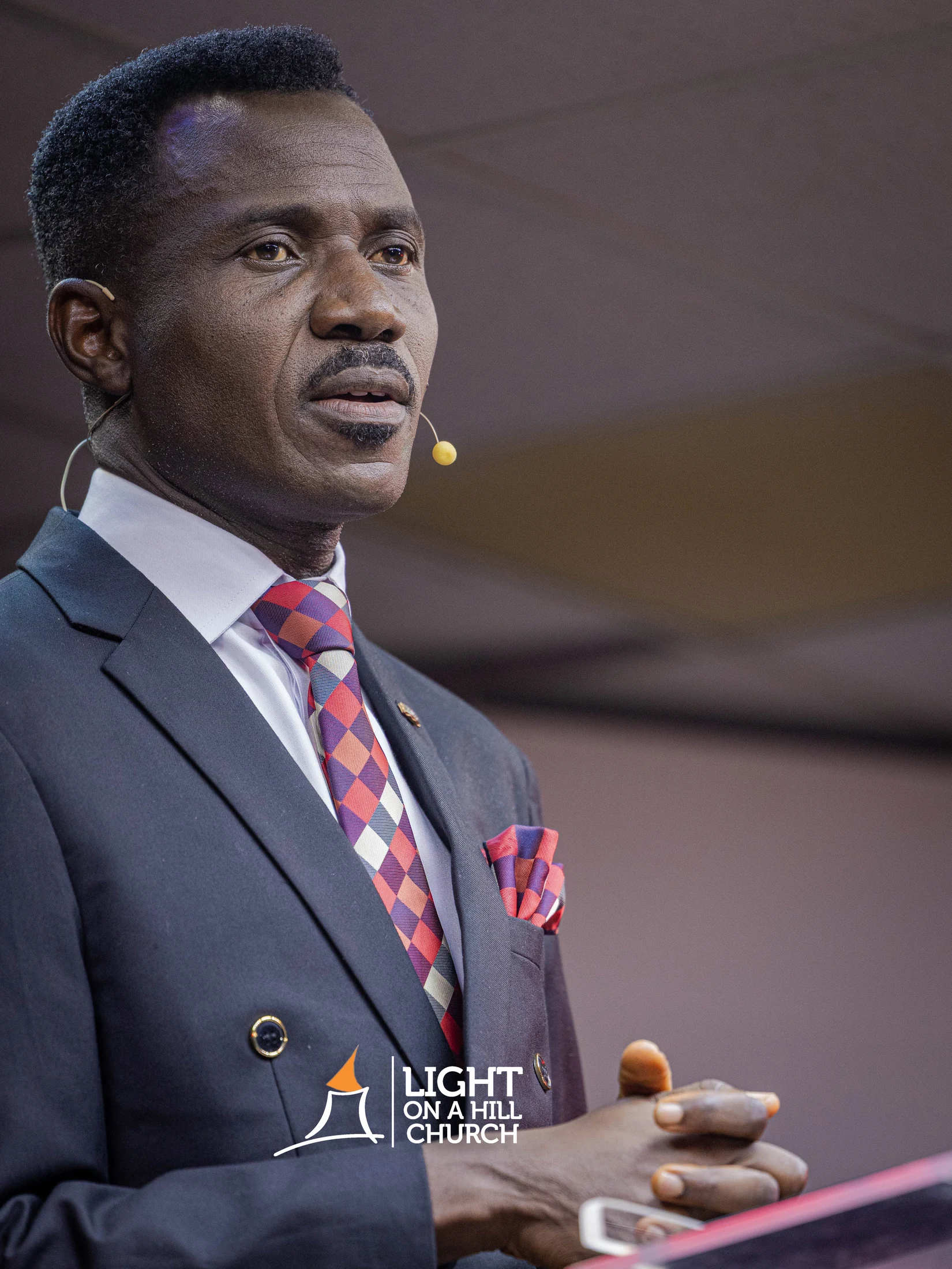 Kayode Braimoh in a suit, speaking with space beside him for the perspective title.